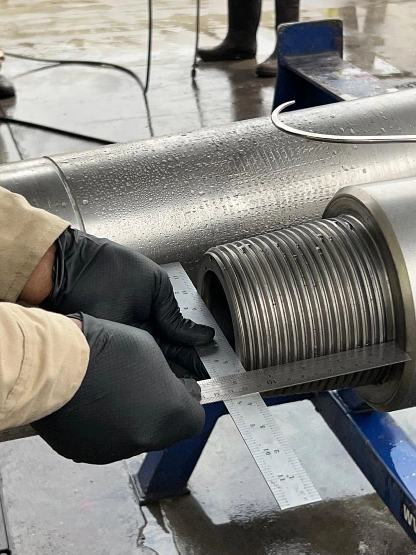 Close-up of a pin thread being checked with a gauge