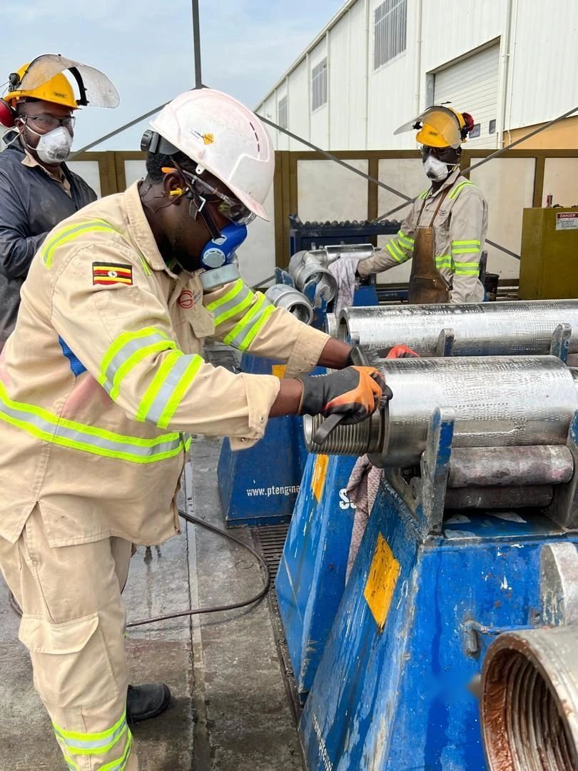 Inspectors examining a tool joint on a drill pipe
